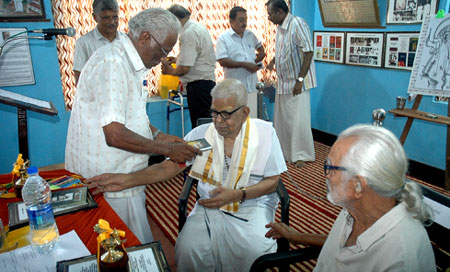 M. Purushothaman presenting his book to Mahakavi Akkitham